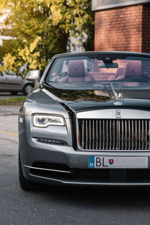 Front view of a silver Rolls Royce Dawn convertible with a pink interior