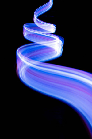 A swirling light trail in shades of blue and purple against a black background.