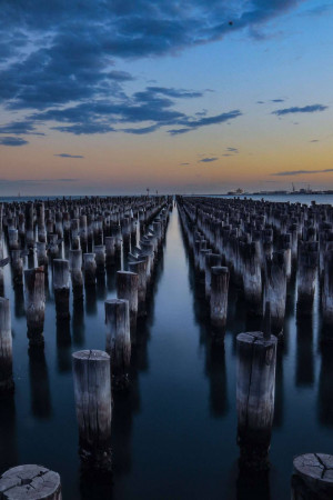 Long exposure shot of old wooden piers extending into the water at sunset