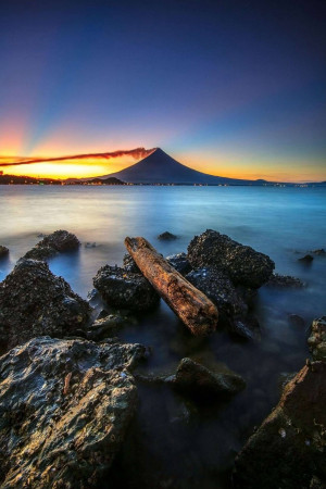 Scenic view of Mount Bromo at sunrise with a log in the foreground