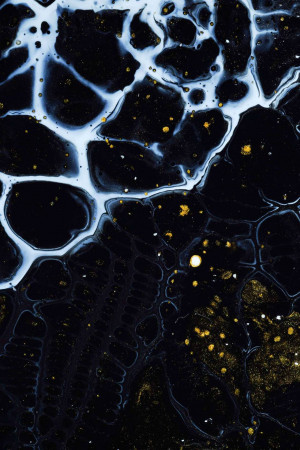 Close-up of abstract fluid art with black, white, and gold colors