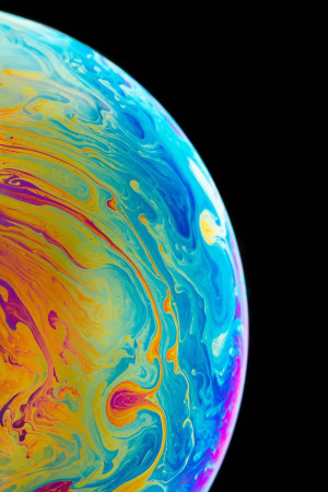 Close-up of a colorful soap bubble against a black background
