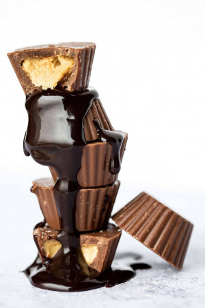 Stacked Reese's Peanut Butter Cups with dripping chocolate