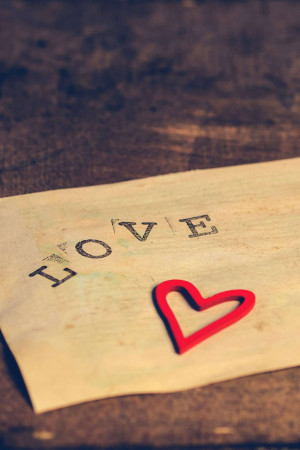 Close-up of a vintage letter with the word 'LOVE' and a red heart