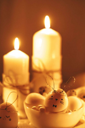 Close-up of Easter eggs and lit candles creating a warm, festive atmosphere.