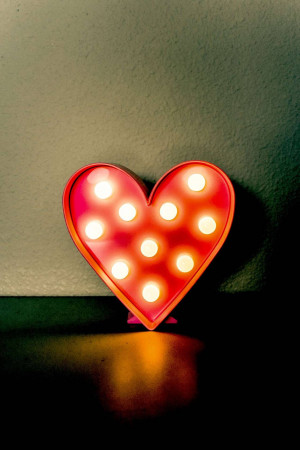 A red heart-shaped light sign with illuminated bulbs.