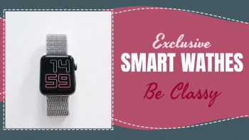 Close-up of a silver mesh strap smartwatch with a black square face displaying '14:59' against a pink background with text 'Exclusive Smartwatches Be Classy'