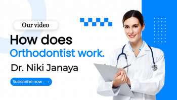 Dr. Niki Janaya, an orthodontist, smiling and holding a clipboard.