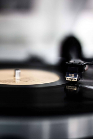 Close-up of a vinyl record player with a focus on the cartridge and record