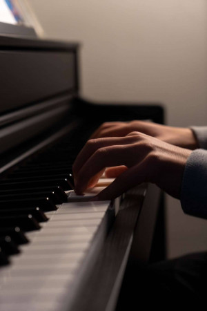 Close-up of hands playing a grand piano