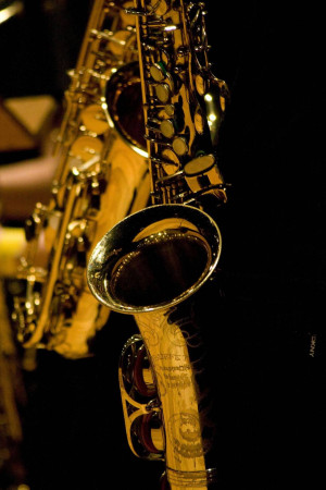Close-up of a golden saxophone against a dark background