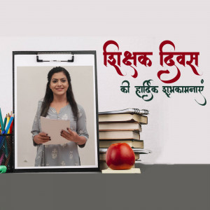 A woman holding a paper in front of a board with 'Happy Teachers Day' written on it.