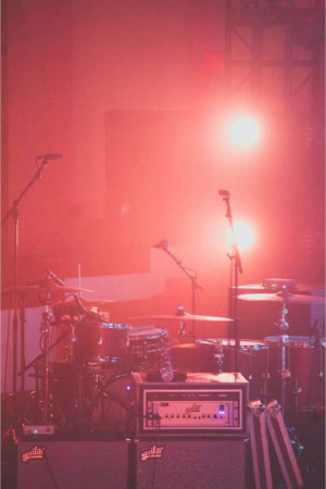 A dimly lit stage with musical instruments and stage lighting.