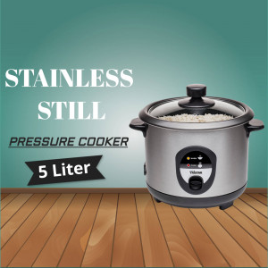 Silver stainless steel pressure cooker with a glass lid on a wooden surface.