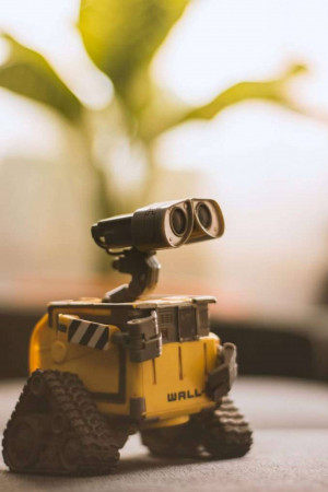 Close-up of a WALL-E robot toy against a blurred green background.