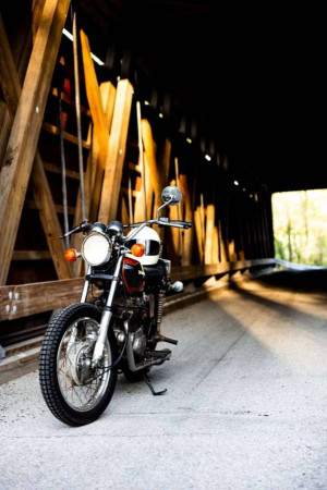 Classic motorcycle parked inside a wooden covered bridge
