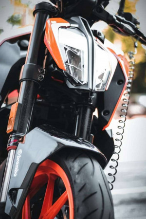 Close-up of a KTM Duke motorcycle's front end, showcasing the headlight and suspension.