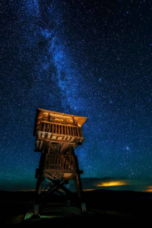 Watchtower silhouetted against a vibrant Milky Way galaxy