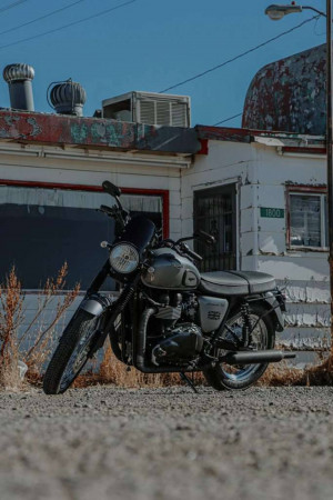 Black Royal Enfield Classic 350 motorcycle parked in front of a weathered building