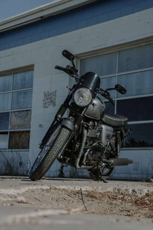 Black Royal Enfield Classic motorcycle parked in front of a building