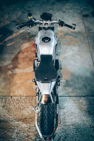 Top-down view of a silver and black motorcycle on a concrete surface