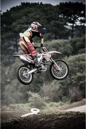 A motocross rider performing a jump on a dirt bike