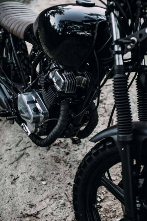 Close-up of a black cafe racer motorcycle engine and front wheel