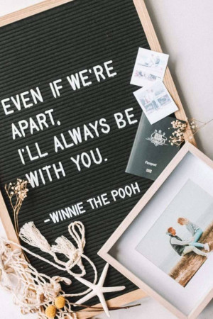 Black felt board with a quote about long distance love, surrounded by travel items.