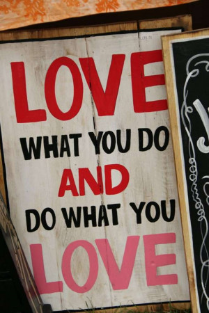 Wooden sign with the words 'Love What You Do' in red and pink lettering.