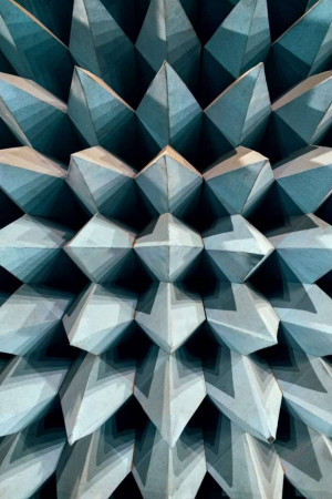 Close-up of a geometric pattern in architecture, featuring repeating triangular shapes in shades of blue and white.