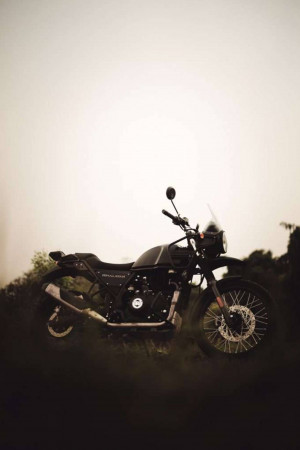 Black Royal Enfield Himalayan motorcycle parked in a field