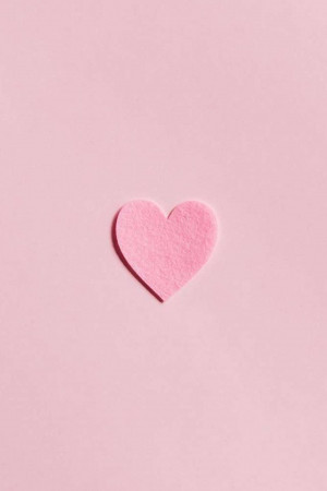 A pink paper heart on a light pink background