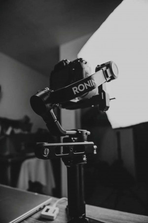 Black Ronin camera stabilizer with DSLR camera attached, used for smooth video recording.