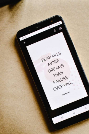 Smartphone displaying a motivational quote about overcoming fear.