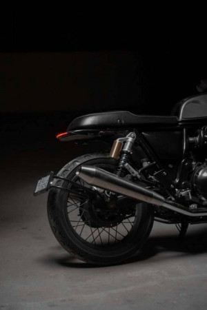 Close-up of a classic black motorcycle rear with chrome exhaust