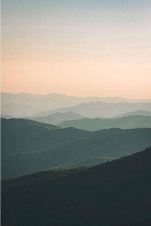 Layered mountains at sunset with soft pastel colors
