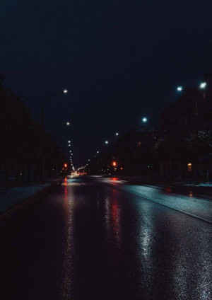 Empty wet road at night with street lights