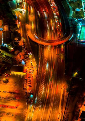 Aerial view of a highway at night with blurred light trails.