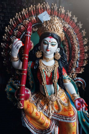 Close-up of a beautifully decorated Goddess Durga idol holding a musical instrument.