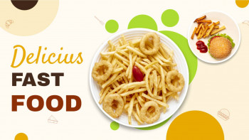 Overhead view of a plate of french fries, onion rings, a burger, and condiments with a colorful background.