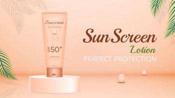 Close-up of a tube of sunscreen lotion with tropical leaves and pearls.