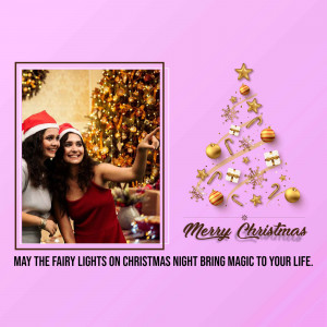 Two women taking a selfie in front of a Christmas tree with festive decorations and text 'Merry Christmas'