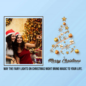 Two women taking a selfie in front of a Christmas tree with festive decorations and text 'Merry Christmas'