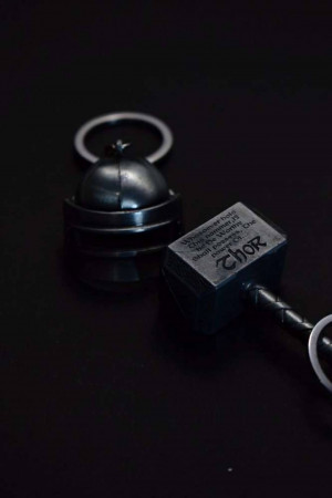 Close-up of a black Thor's hammer keychain with the inscription 'Thor' on the hammerhead.