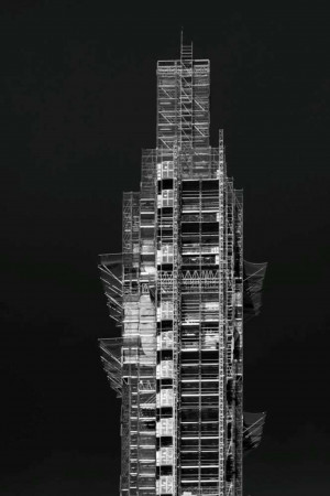 Black and white image of the Burj Khalifa skyscraper in Dubai, covered in scaffolding during construction.