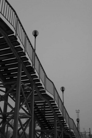 Black and white image of a metal stairway leading upwards