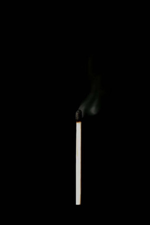 A single lit match against a black background
