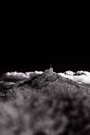 Black and white image of a shrine on a mountaintop surrounded by clouds