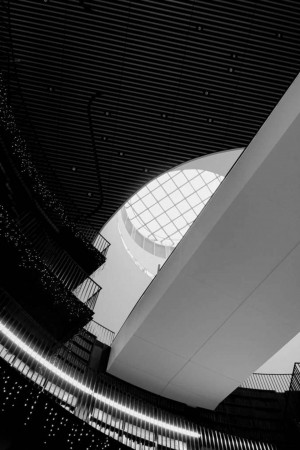 Black and white photograph of a modern building interior with a circular skylight.