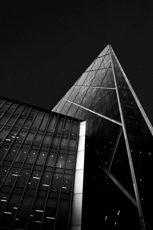 Black and white photograph of a modern glass building with sharp angles.